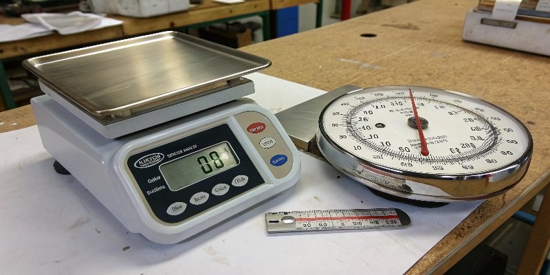 Digital vs Analog Scale Comparison A modern digital scale next to a classic analog scale on a workbench