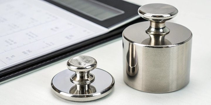 Certified Calibration Weight A certificate of calibration next to a highly polished F1 class weight.