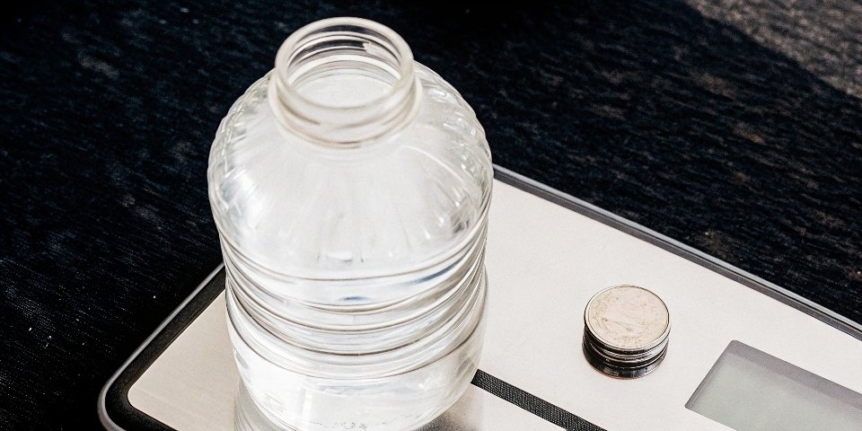 A U.S. nickel and a bottle of water next to a digital scale