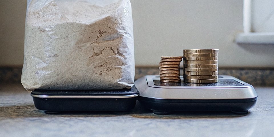 Household Items for Scale Calibration Unopened bag of flour and coins next to a kitchen scale