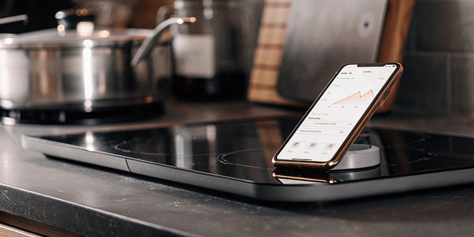 A smart kitchen scale connected to a smartphone app showing nutritional data