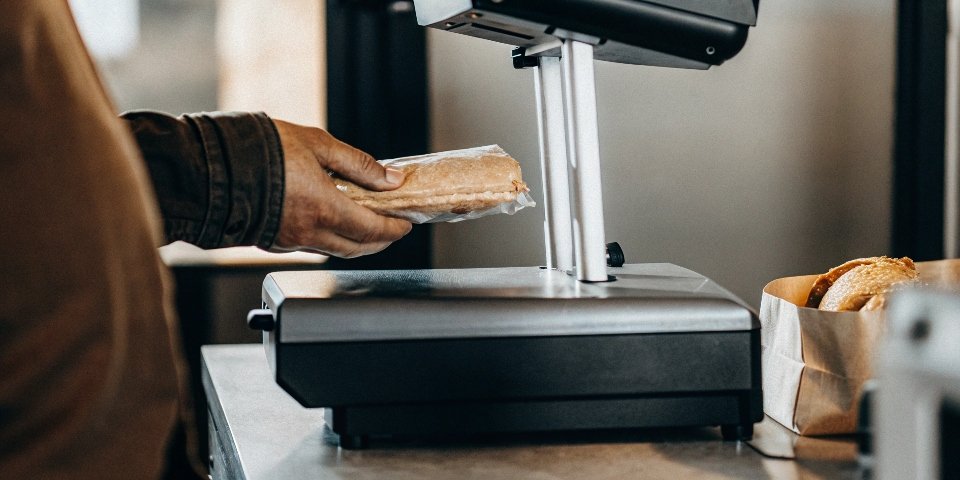 A close-up of a scale printing a price label for a pre-packaged item in a deli.