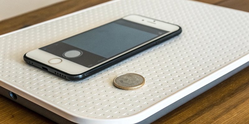 Phone Scale App A smartphone with a scale app on the screen, weighing a small coin