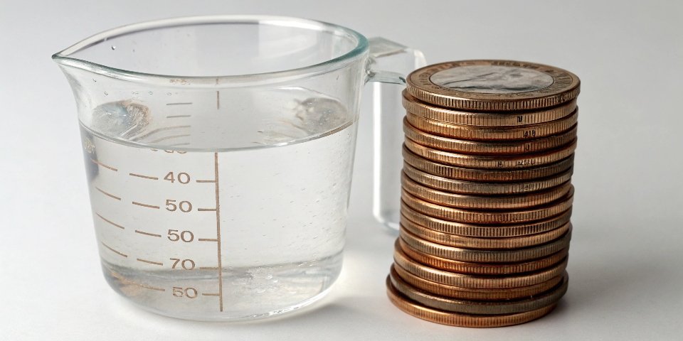 Using Water or Coins for Calibration A measuring cup with water and a stack of coins side-by-side