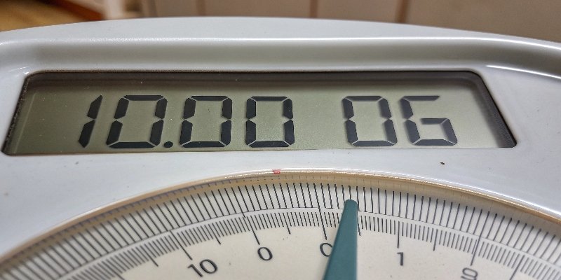 Accuracy Comparison between Digital and Analog Scale A side-by-side closeup of a digital readout showing 100.01g and an analog needle pointing near 100g