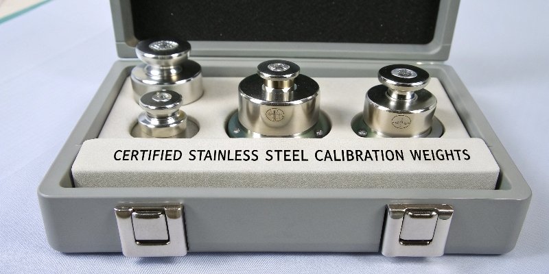 Calibration Weights Equipment A set of certified stainless steel calibration weights in a case