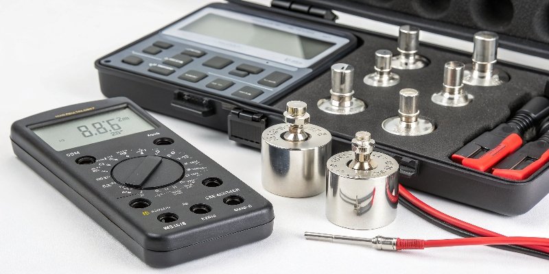 Load Cell Calibration Tools An array of calibration tools including certified weights and a digital multimeter