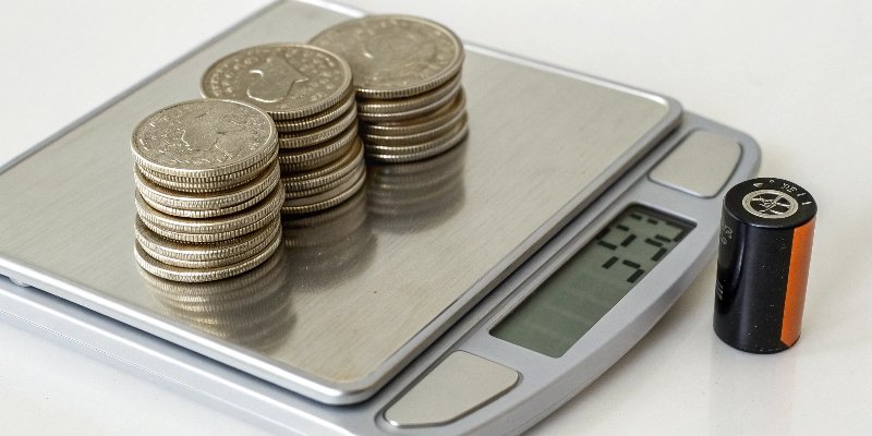 Using Nickels to Calibrate a Scale Ten US nickels stacked next to a digital scale showing 50g