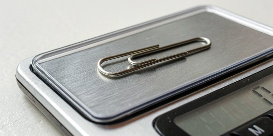 A scale weighing a 1 gram object A single paperclip on a digital scale showing 1.00 g