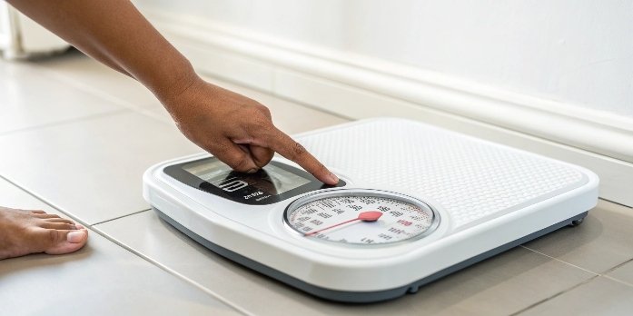 Reset a floor scale A person's finger about to press a reset button on a scale's indicator