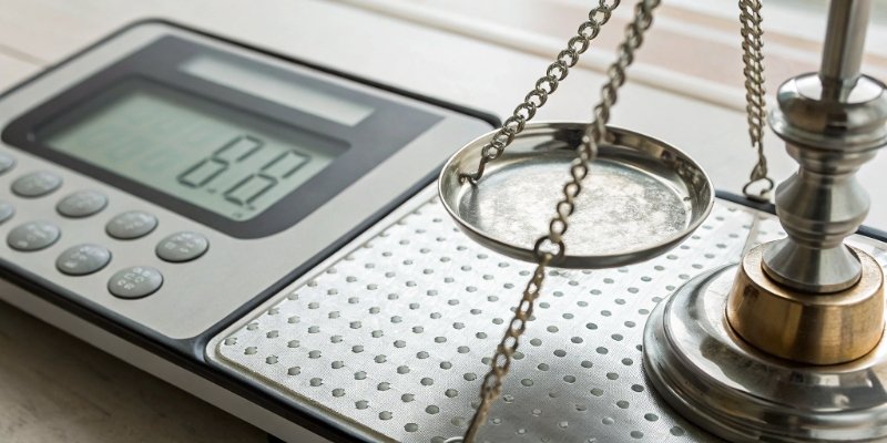 Readability vs. Accuracy on an Industrial Scale A close-up of a digital scale display showing many decimal places, contrasted with a certified calibration weight.