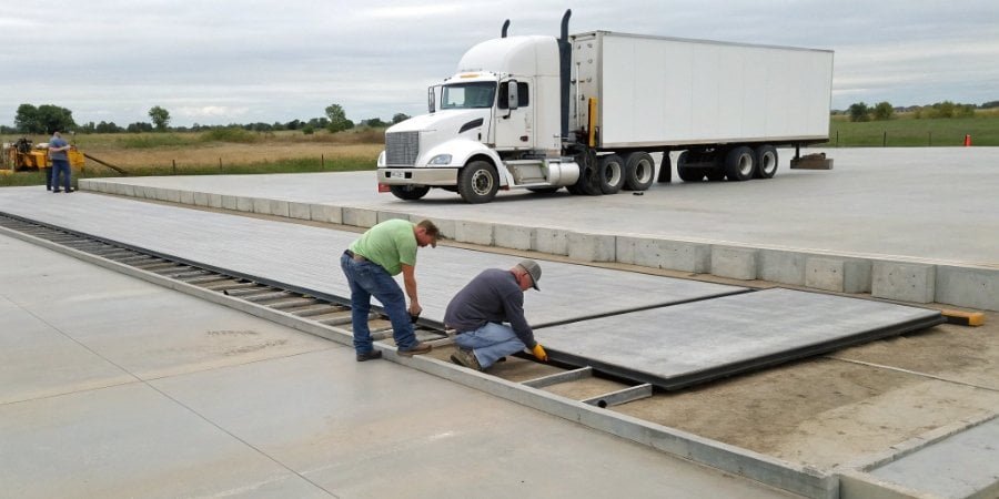 A surface-mounted truck scale being installed on a prepared concrete foundation