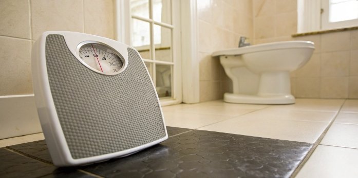 Why Your Scale Reading Changes Daily A bathroom scale showing fluctuating numbers