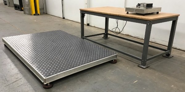 Platform Scale vs. Bench Scale Placement and Use A large, floor-mounted platform scale with a ramp, next to a smaller scale on a workbench