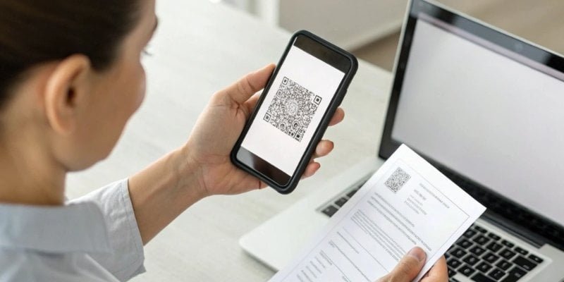 Online Certificate Verification A person holding a smartphone, scanning a QR code on a certificate to verify its authenticity online.