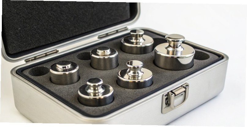 Certified Calibration Weights A set of certified calibration weights in a protective case.