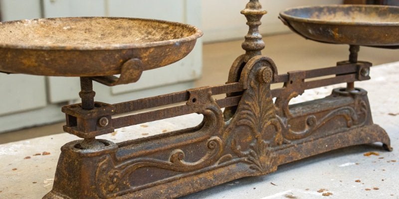An old, partially rusted metal scale before cleaning