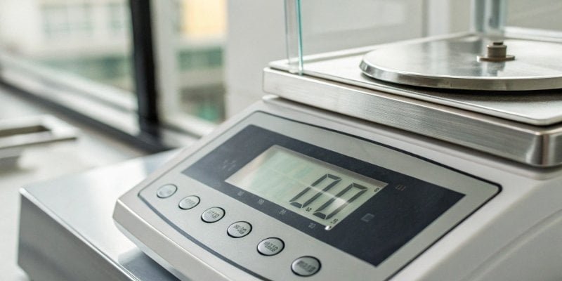 A close-up shot of the digital display of a precision balance showing a measurement in micrograms.