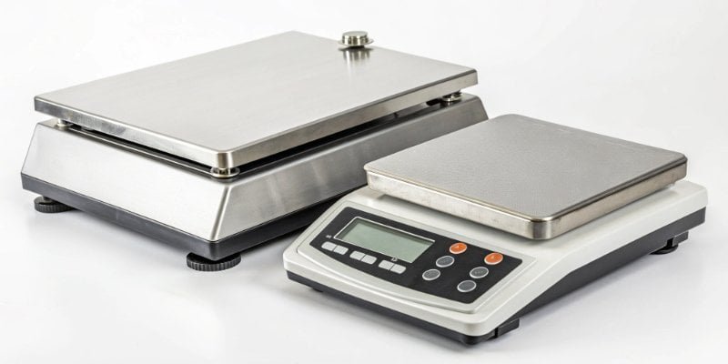 A modern industrial scale with a digital display next to an older model