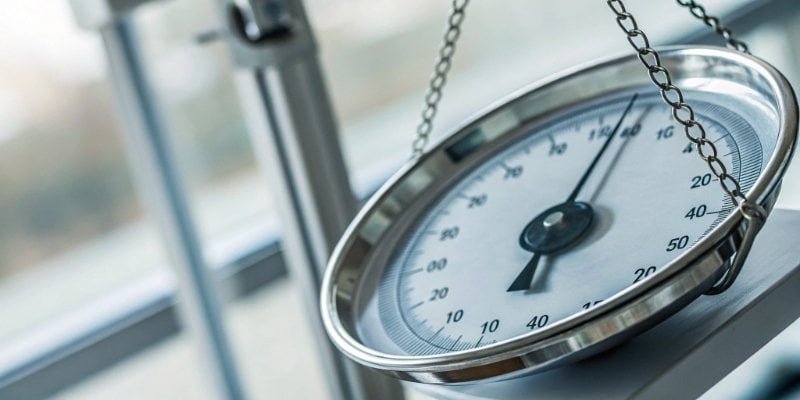 Digital Scale Reliability and Precision A close-up of a clear digital display showing a precise weight, contrasted with a blurry image of an analogue dial.