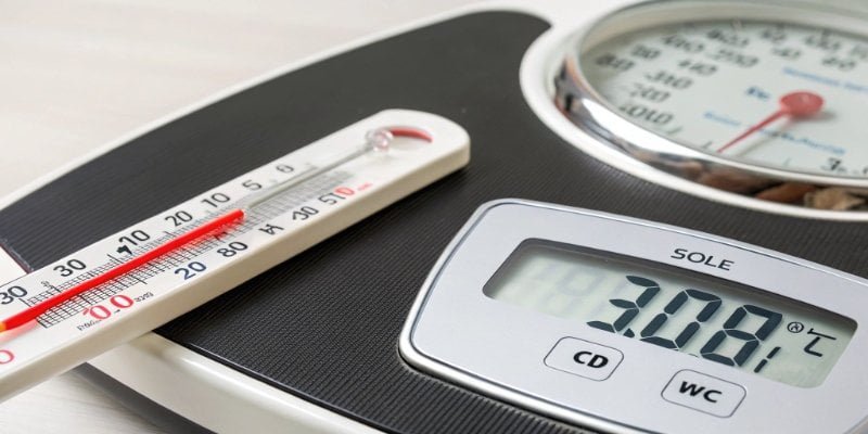 A digital scale with a thermometer next to it showing a high temperature