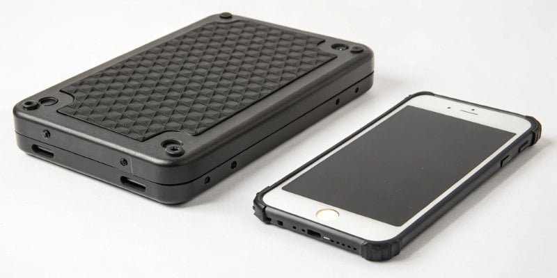 A rugged industrial scale controller next to a fragile smartphone