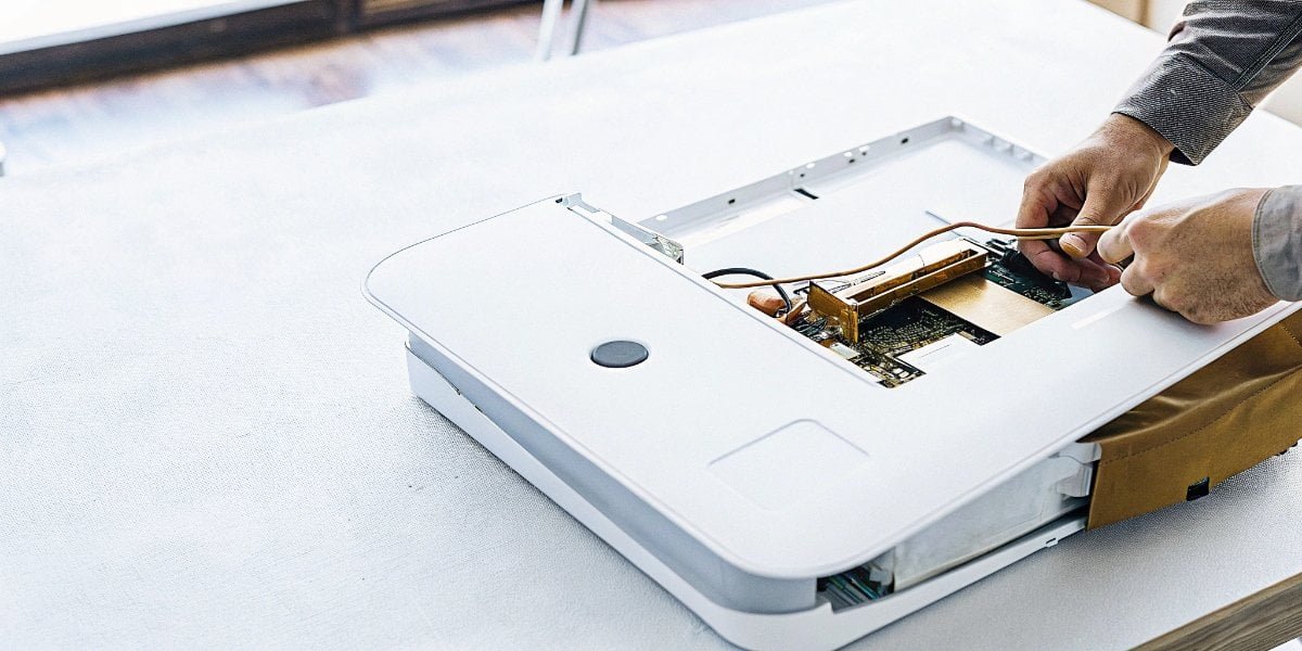 A technician repairing an industrial weighing scale by replacing a component