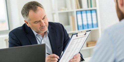 Key Purchasing Factors for Business Solutions A manager reviewing a checklist with factors like TCO, support, and security