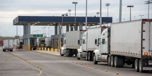 Scale House in Logistics and Transport A fleet of trucks lined up near a scale house at a logistics hub.