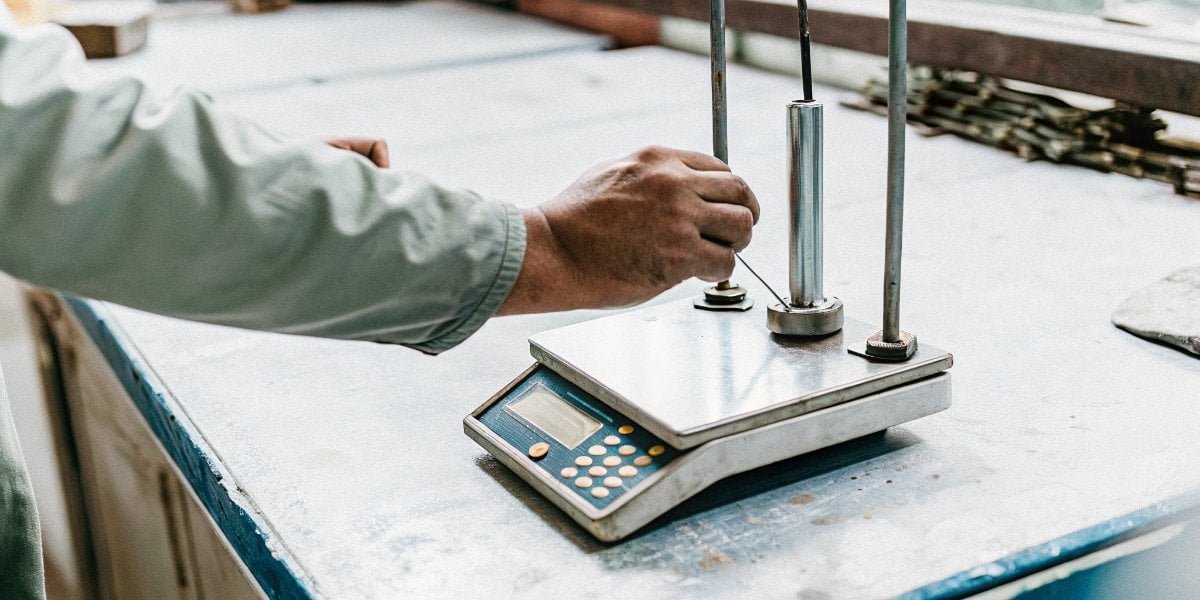Maintaining the Accuracy of a Digital Scale A technician performing calibration on an industrial digital scale