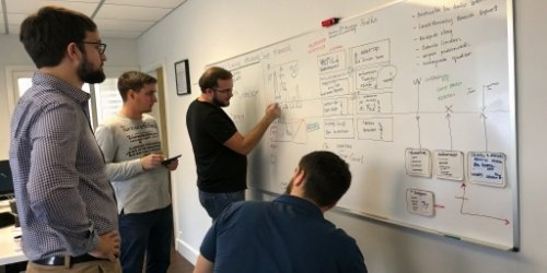 a system integrator's team collaborating on a custom weighing solution on a whiteboard