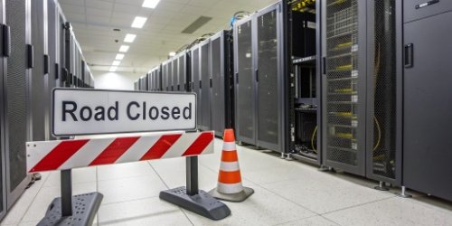 A "road closed" sign in front of a computer server, symbolizing access limits