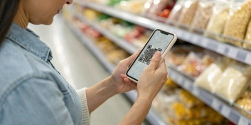 Consumer Demand and Traceability A customer scanning a QR code on a food package to see its supply chain history displayed on a smartphone.