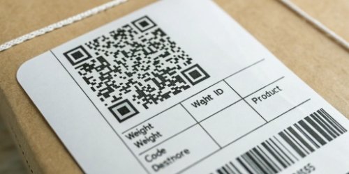 A close-up of a freshly printed label showing a QR code, weight, product ID, and destination code