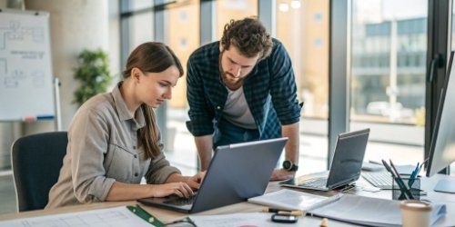 A support engineer working closely with a software developer, symbolizing partnership and support.