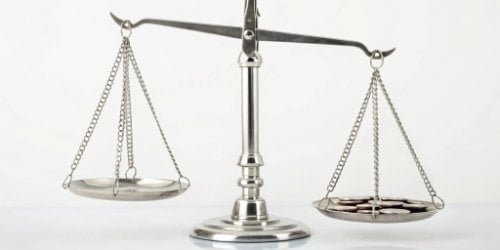 A balanced scale with 'Cost' on one side and 'Revenue' on the other