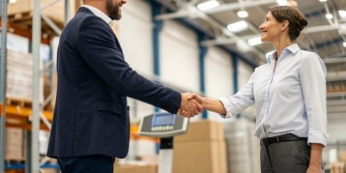 Building a Strategic Partnership a handshake between a software vendor and a client in a warehouse setting, with a smart scale in the background