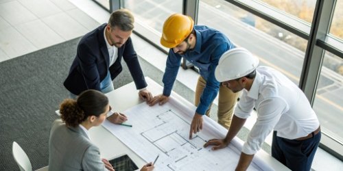 Engineers from two companies collaborating over a technical diagram