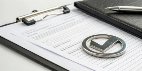An official-looking document with a checkmark next to a stainless steel icon, symbolizing regulatory compliance