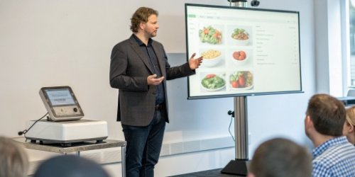 A software vendor confidently presenting a food traceability solution that includes both software and hardware.