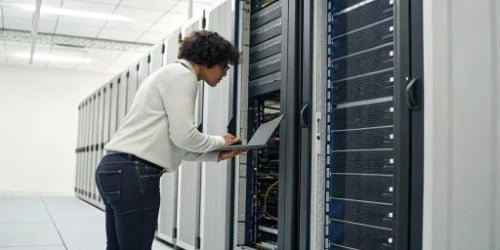 A person inspecting a server rack, symbolizing quality control and stability