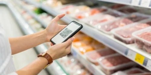 A consumer a supermarket scanning a QR code on a package of meat with their smartphone.