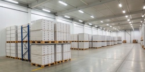 A well-organized cold storage warehouse with neatly stacked boxes on pallets.