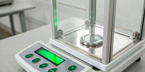 A close-up of a digital scale display showing a weight within the green tolerance zone.