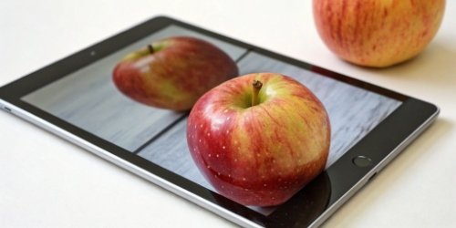 Simplifying Sorting with Images A close-up of a tablet screen showing a picture of an apple, with the actual apple next to it for comparison.