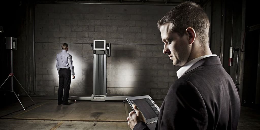 A manager reviewing data on a tablet in front of a weighing system